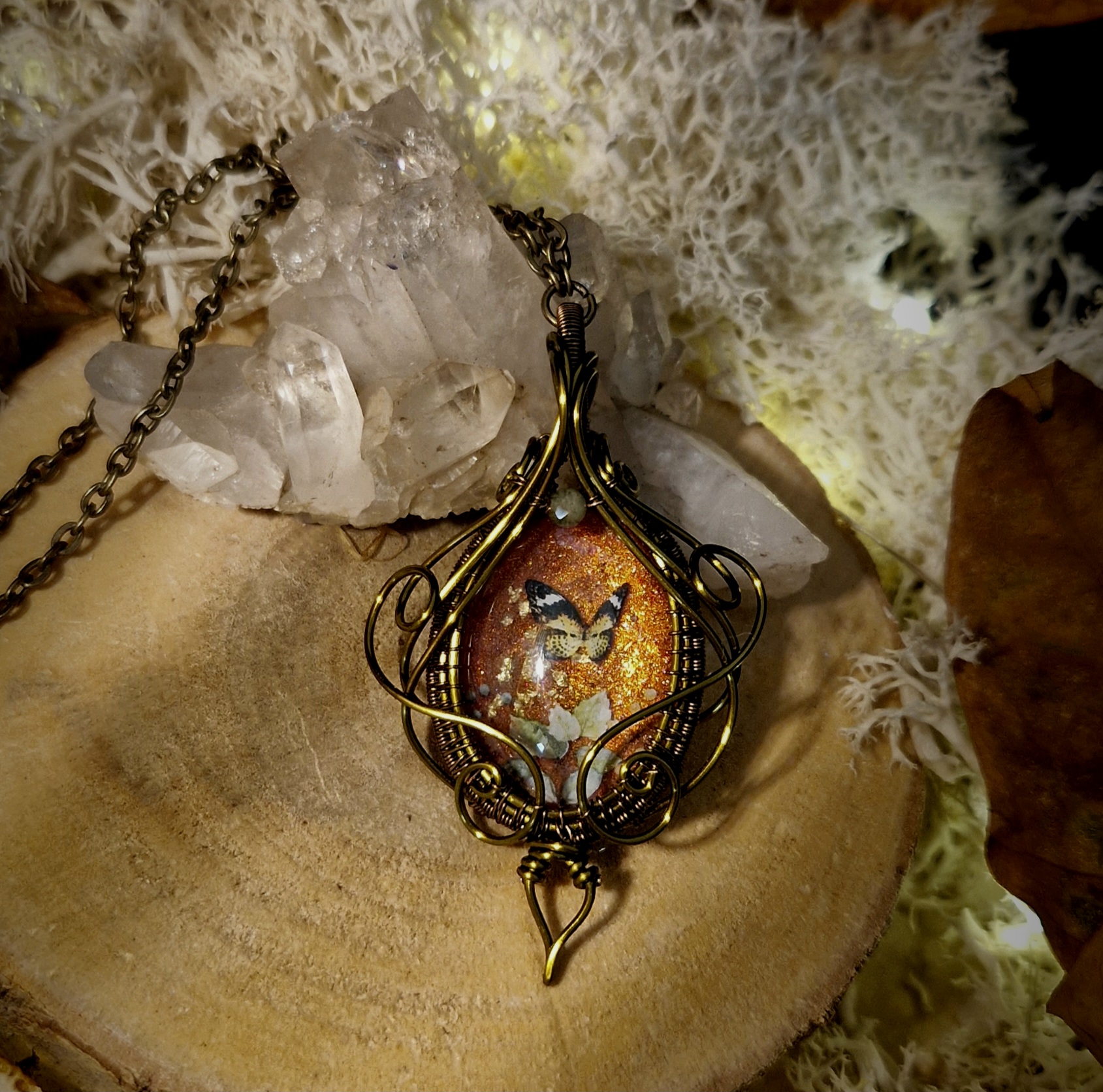 Petit pendentif elfique en verre et pierre naturelle de tourmaline décors papillons sur fond orangé enveloppé entrelacs de fils de cuivre vernis couleur bronze antique chaîne en métal bronze antique